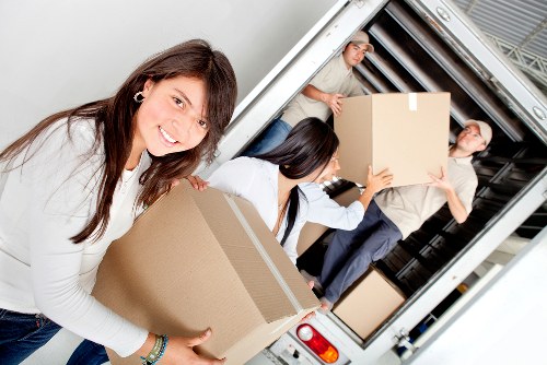 Movers wrapping and protecting furniture for transport